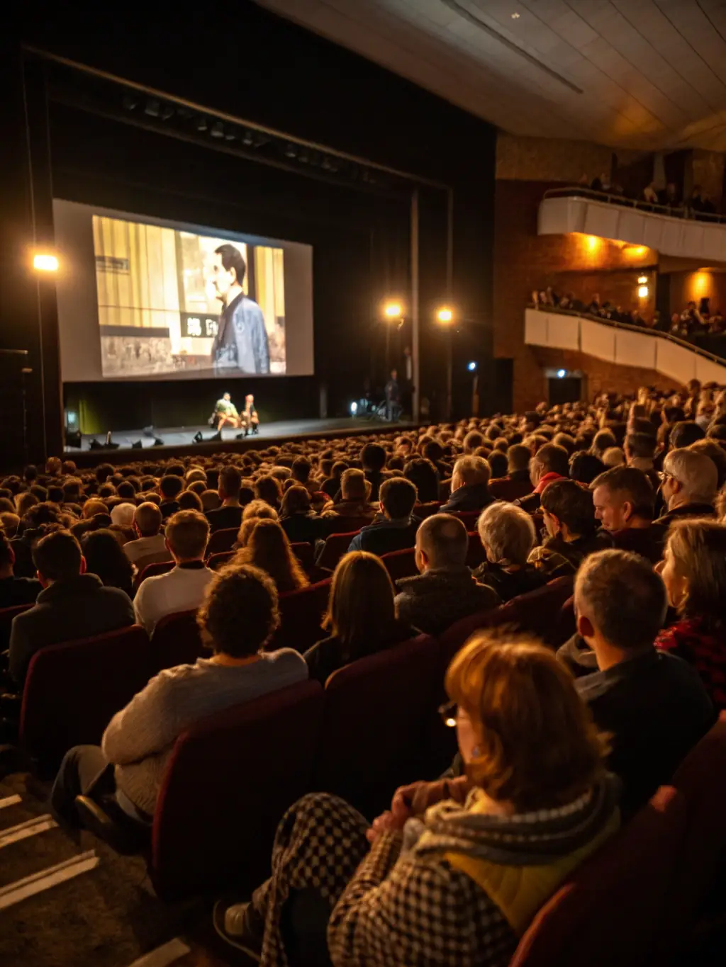 A vibrant image of a cinema hall with an audience watching a film, highlighting the communal experience of screenings.